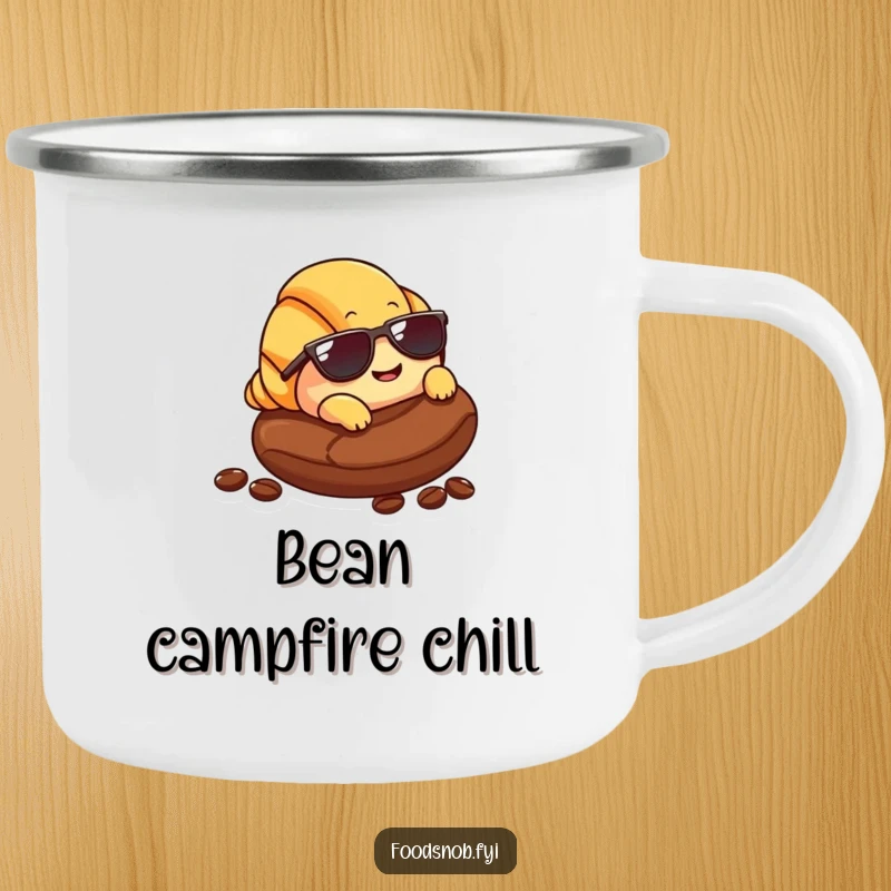 Funny Croissant Camping Mug: An enamel mug featuring a smiling croissant with sunglasses lounging on a coffee bean, ideal for outdoor relaxation.