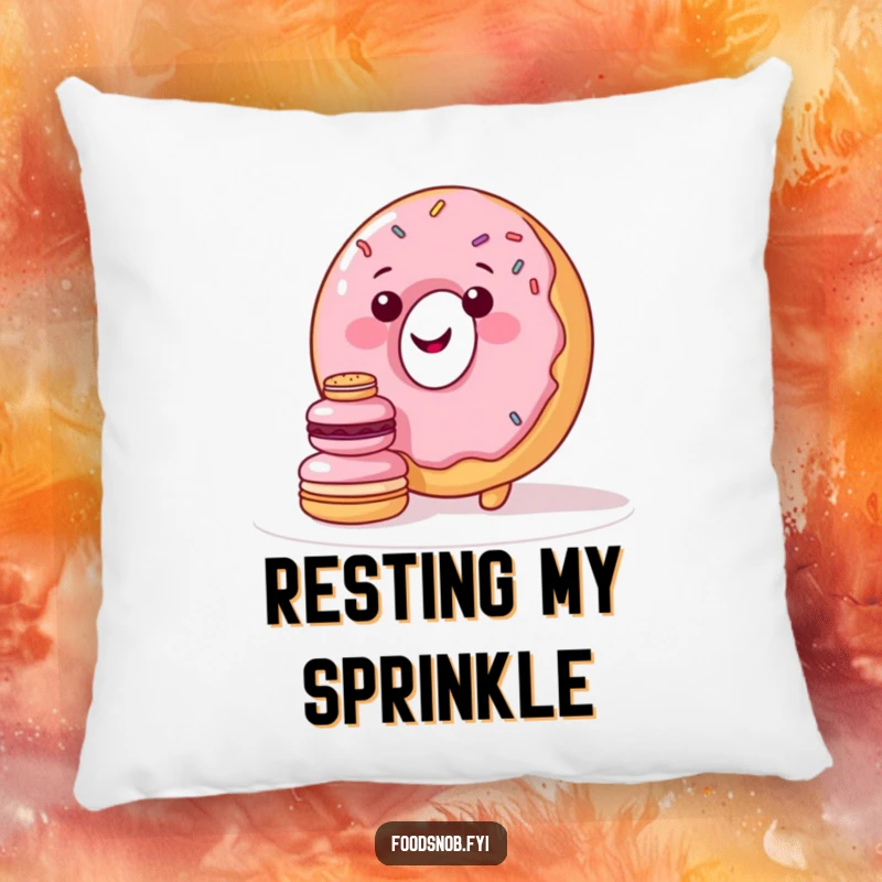 Funny pillow featuring a smiling donut character with sprinkles trying to stack miniature macarons, perfect for cozy, sweet decor.