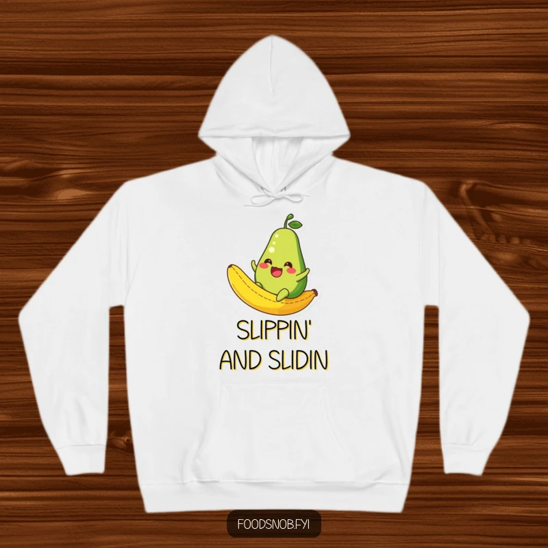 Funny Avocado Hoodie: A warm hoodie featuring a happy avocado character sliding down a banana peel, perfect for comfortable humor.